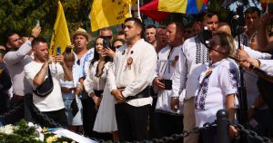 AUR, conflict la Țebea înainte de moțiunile de cenzură. Fotograful lui Simion și-a pus picioarele pe mormânt.