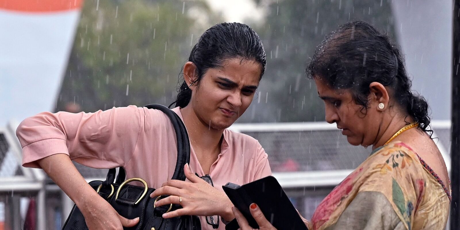 People brave through rains near Kartavya Path, in New Delhi.