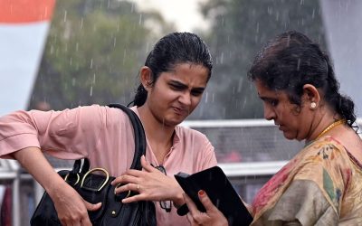 People brave through rains near Kartavya Path, in New Delhi.