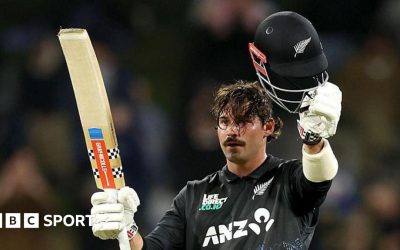 Tim Robinson raises his bat and helmet after reaching his century