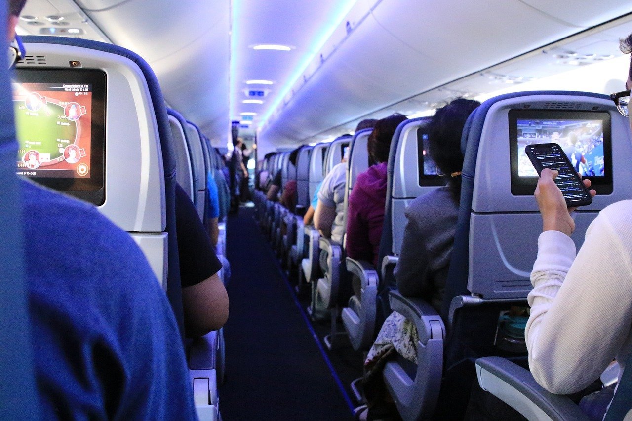 [ad_1] Oameni îmbrăcați în costume și cu pălării urcă respectuos în avion, fiecare având un mic bagaj de mână
