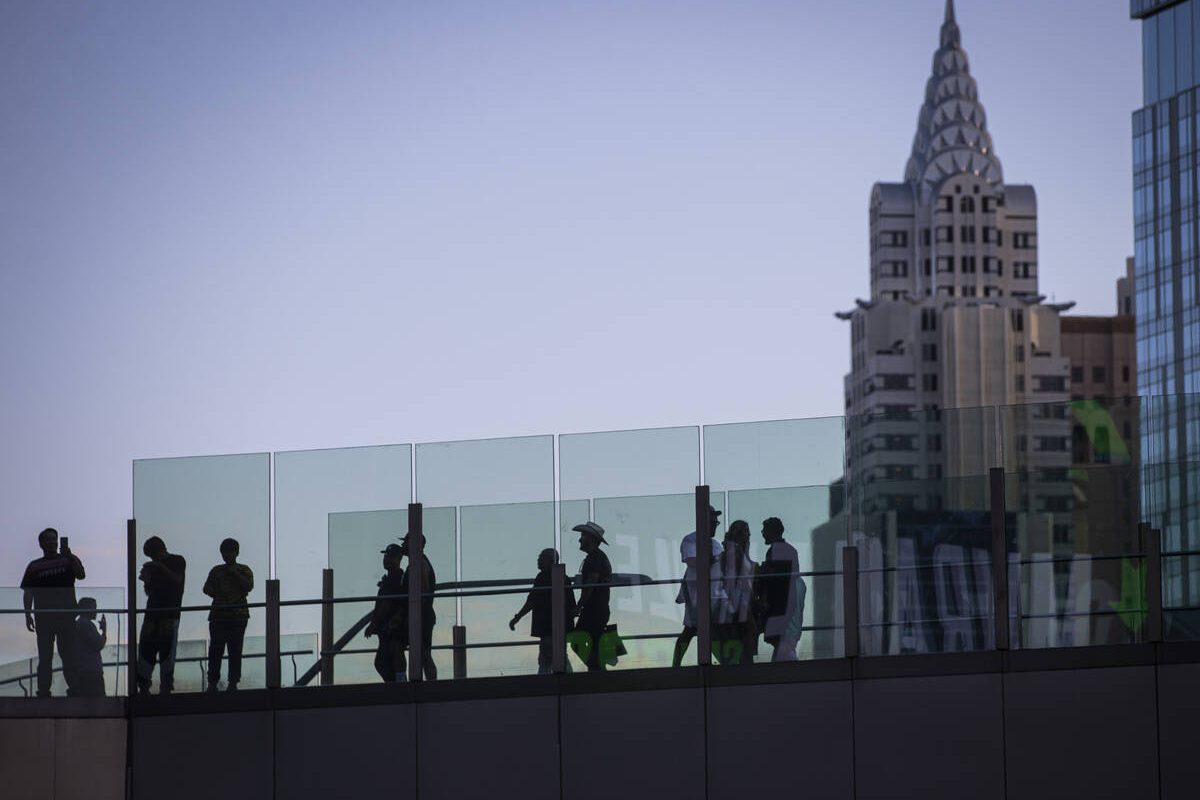 People cross a pedestrian bridge along the Las Vegas Strip during Labor Day weekend on Sunday, ...