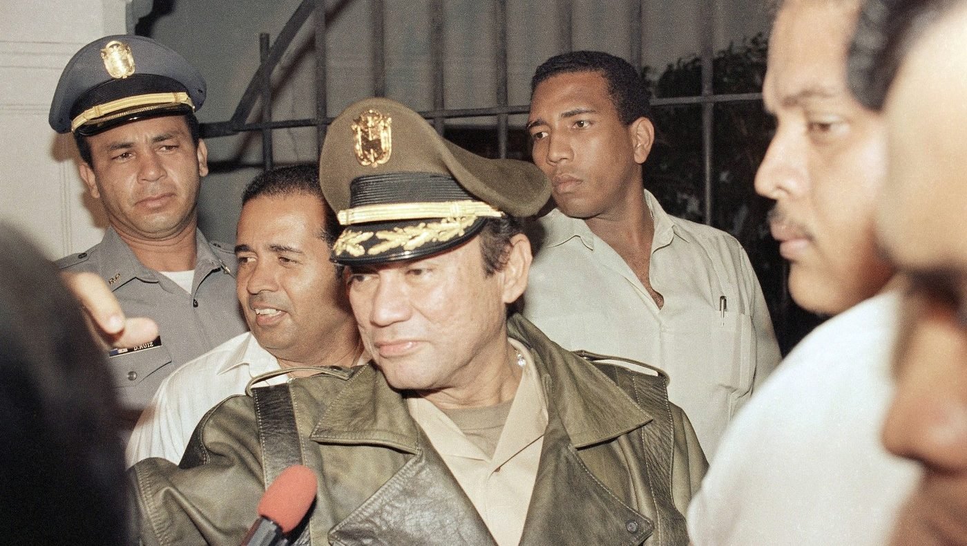Generalul Manuel Antonio Noriega, omul forte al Panama, salută susținătorii săi, pe 21 martie 1988, la palatul prezidențial din Panama City. Îmbrăcat într-o jachetă de piele neagră, Noriega a sosit la palat după discursul președintelui Manuel Solis Palma, care a anunțat că Noriega va demisiona în anumite condiții.