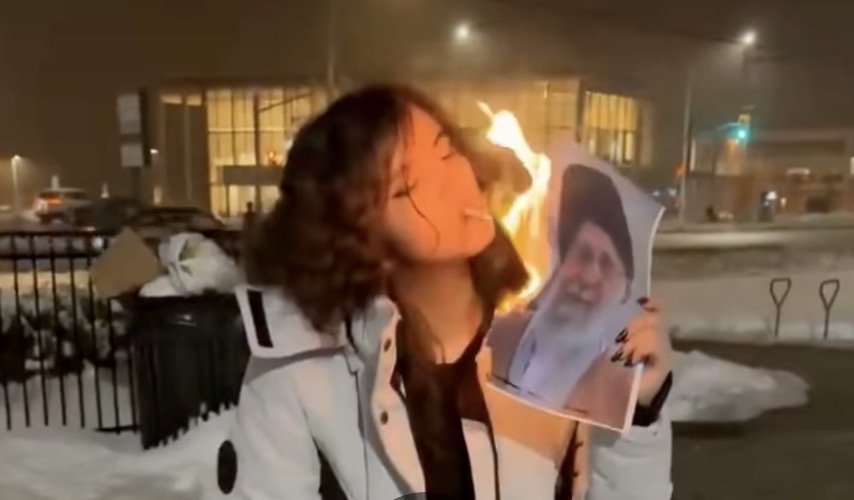 O imagine ce a devenit virală pe rețelele sociale în ultimele zile surprinde o adolescentă iraniană aprinzând o țigară folosind un portret în flăcări al liderului suprem Ali Khamenei