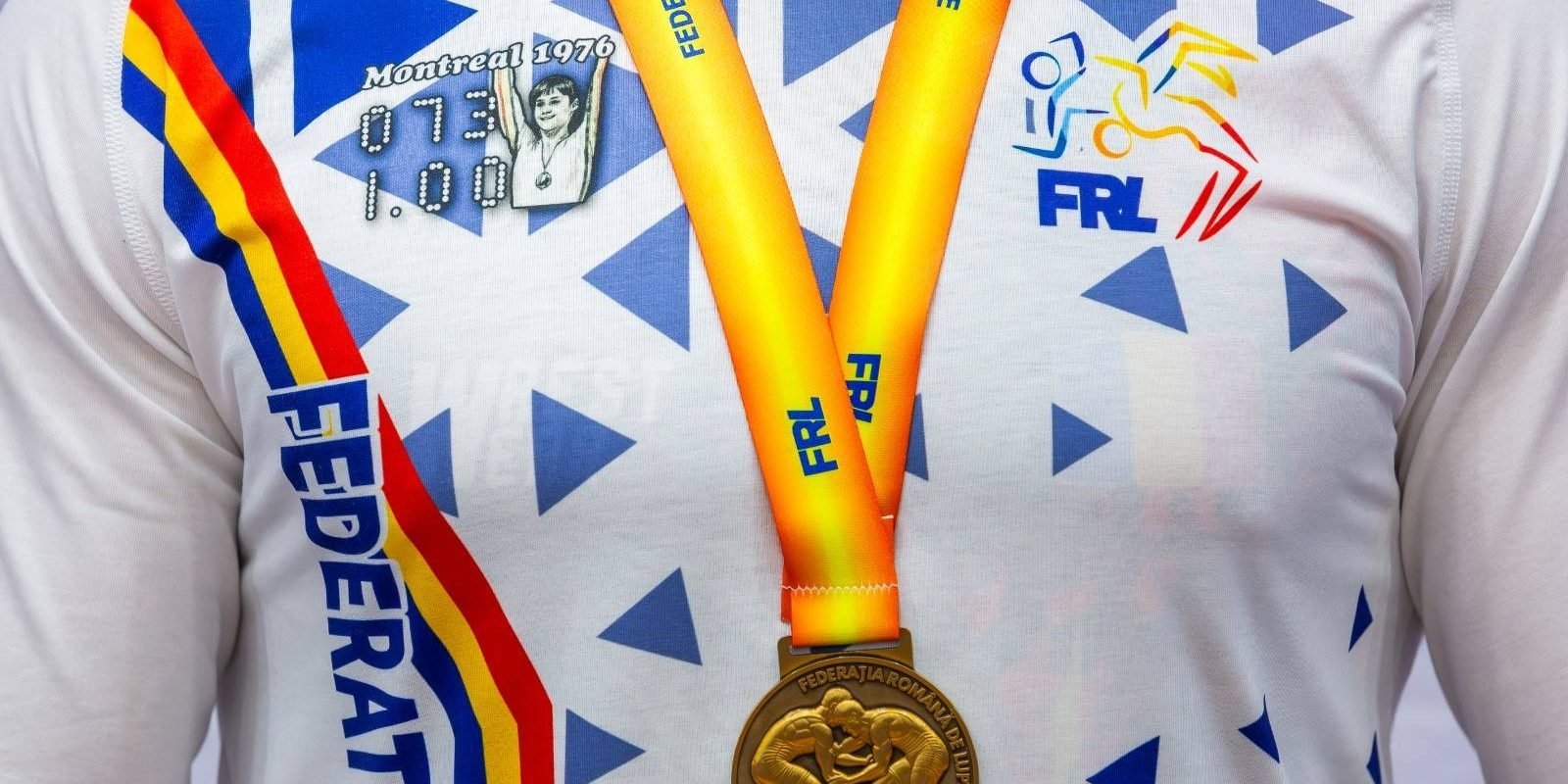Nadia Comăneci, simbolul excelenței sportive, pe tricourile luptătorilor români La jumătate de secol de la momentul istoric când Nadia Comăneci obținea prima notă de zece din istoria gimnasticii, Federația Română de Lupte face un gest inedit